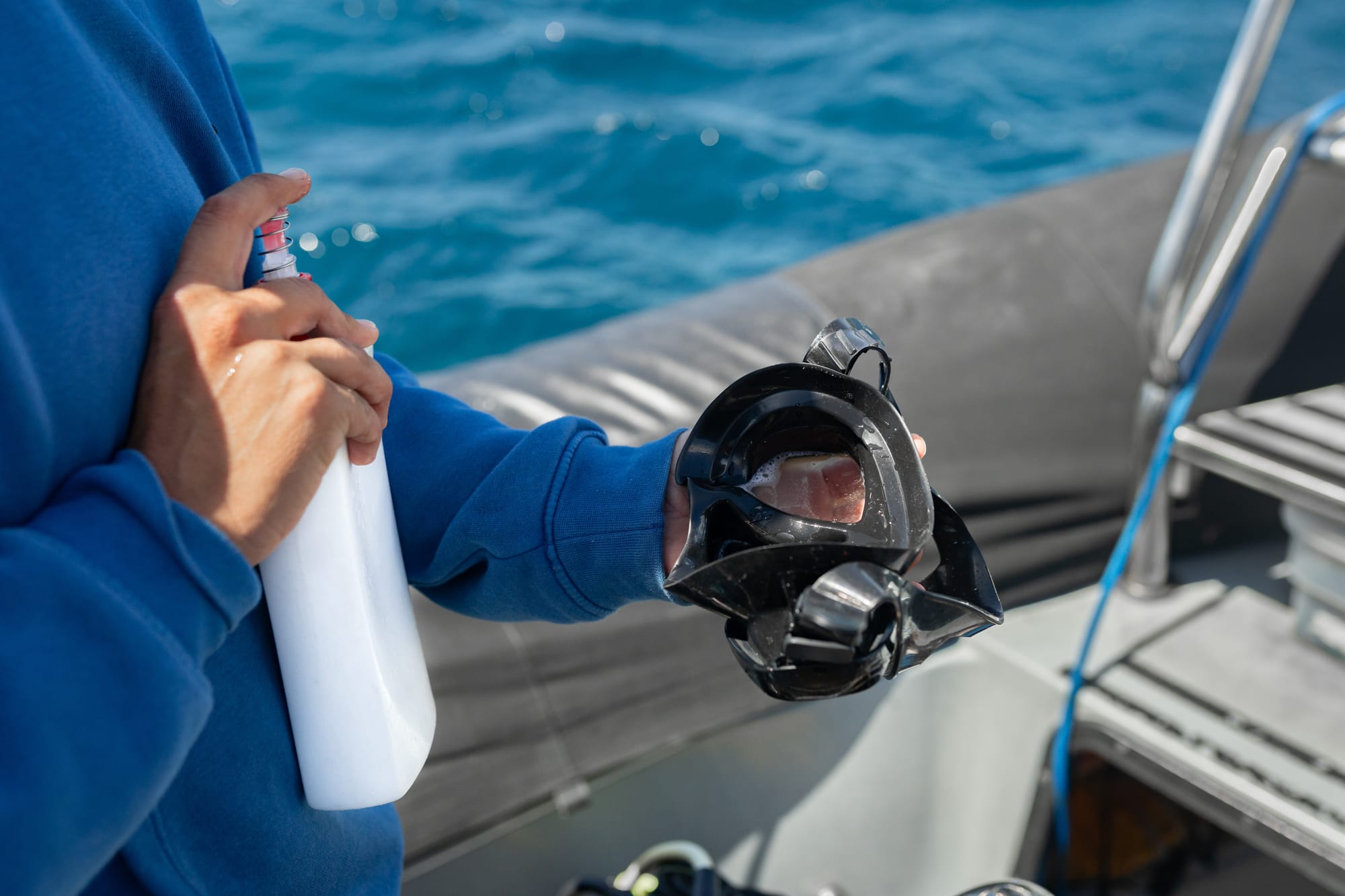 Scuba diver applying shampoo in their mask to prevent fogging