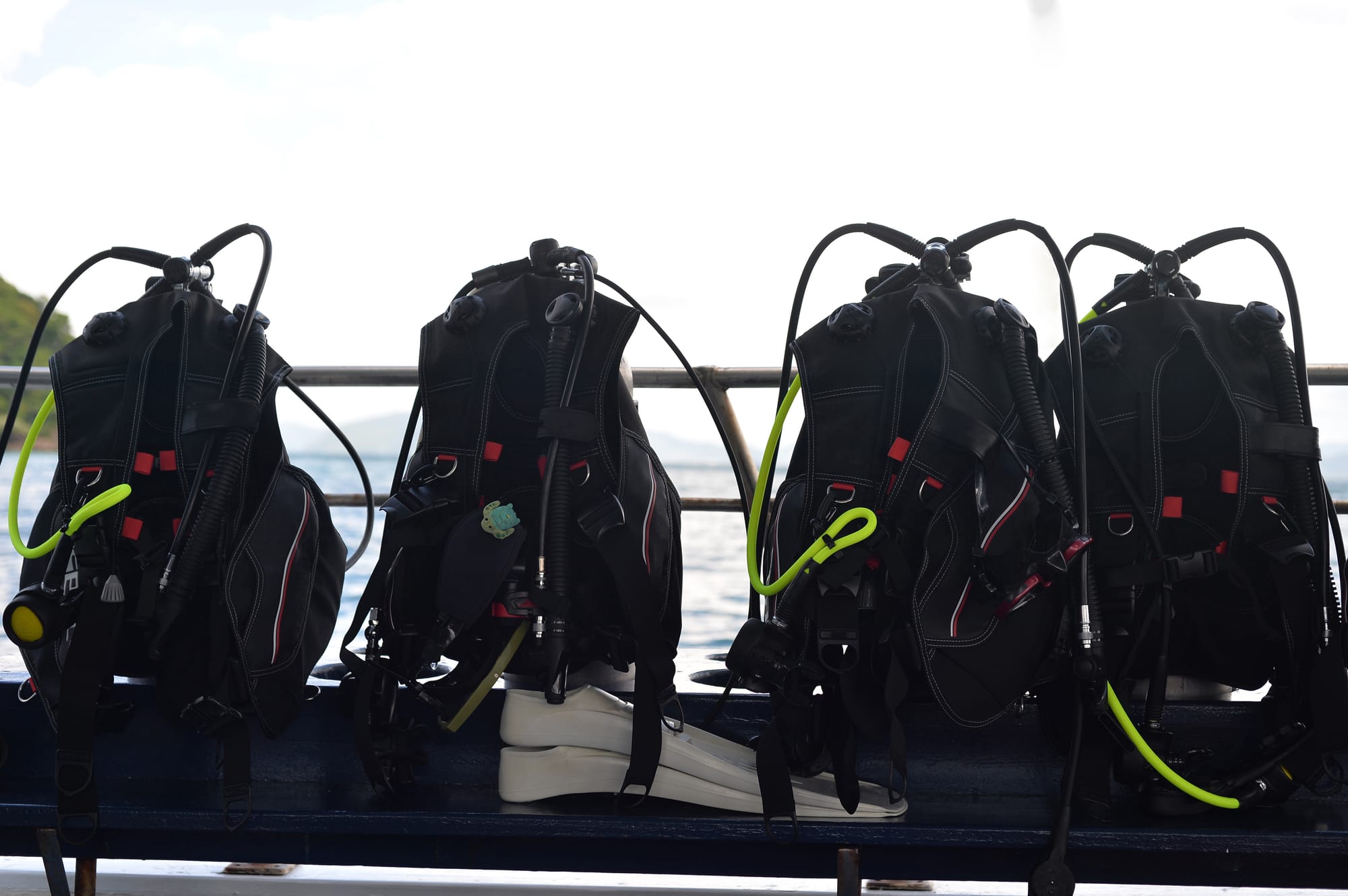 Scuba Diving BCDs attached to tanks and regulators on a diving boat