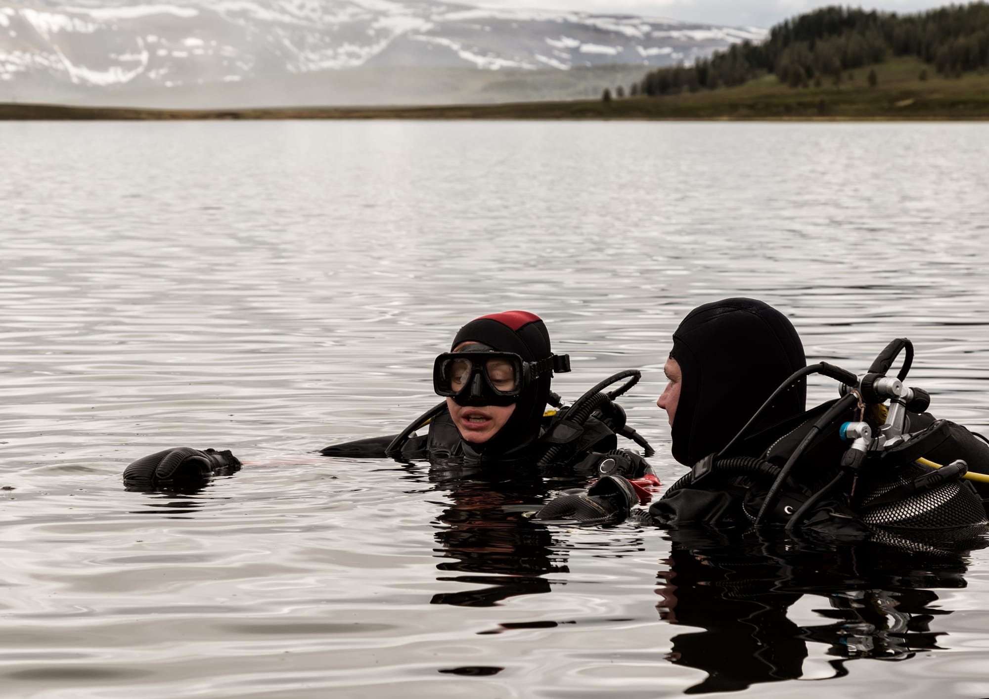 Scuba-divers diving in a cold german lake