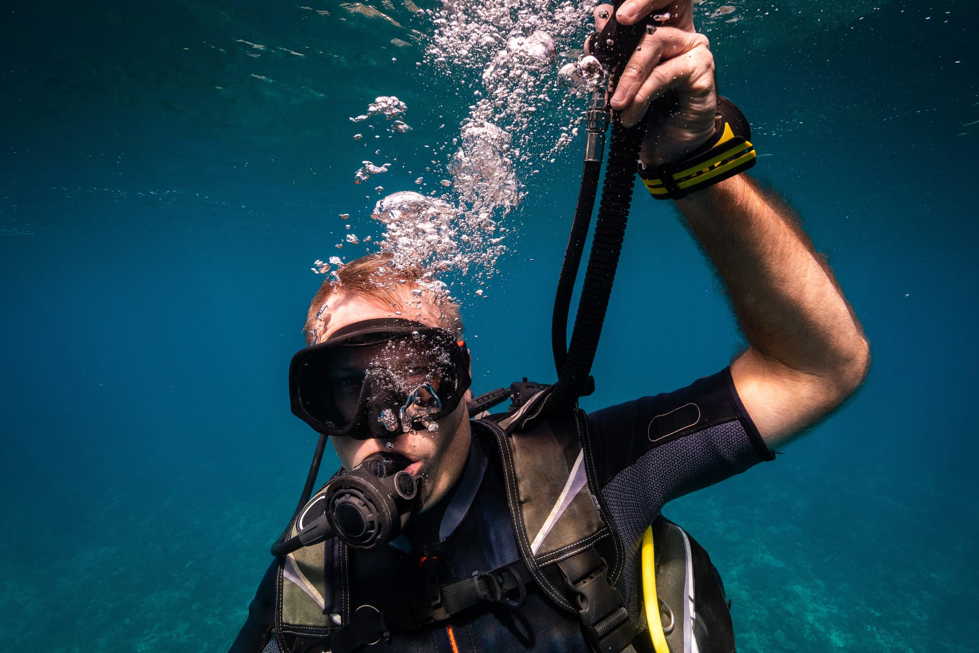 Diver deflating their BCD, or Buoyancy Control Device underwater
