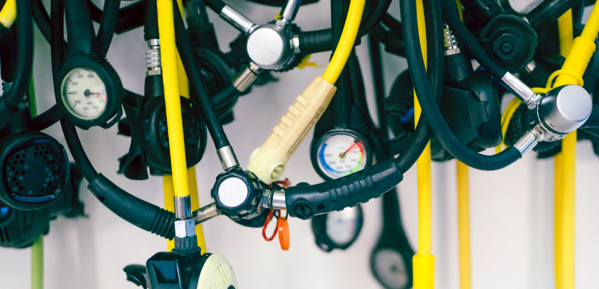 multiple scuba diving regulators on the display, first stages with multiple hoses
