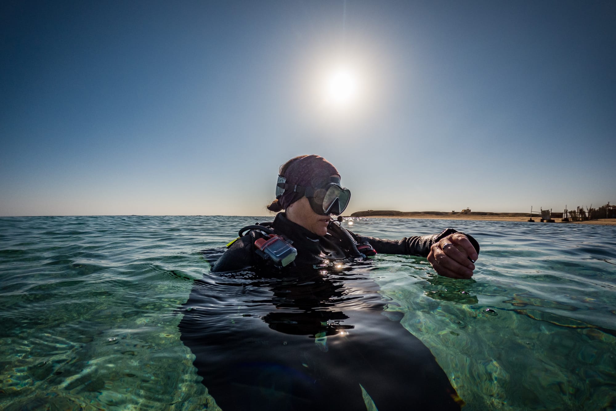 Scuba-diver looking at their dive computer on the surface.