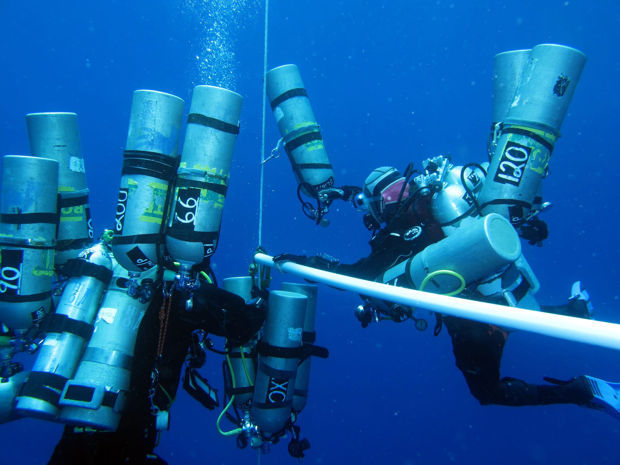 Technical divers on a decompression stop, with many stages around them