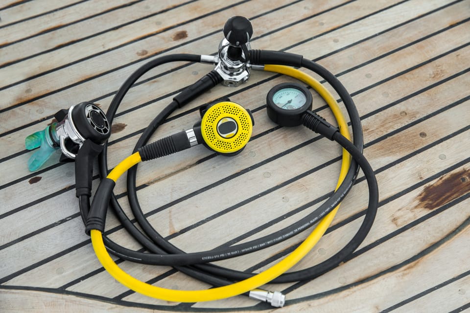 A yoke-style scuba diving regulator first stage with 2 second stages